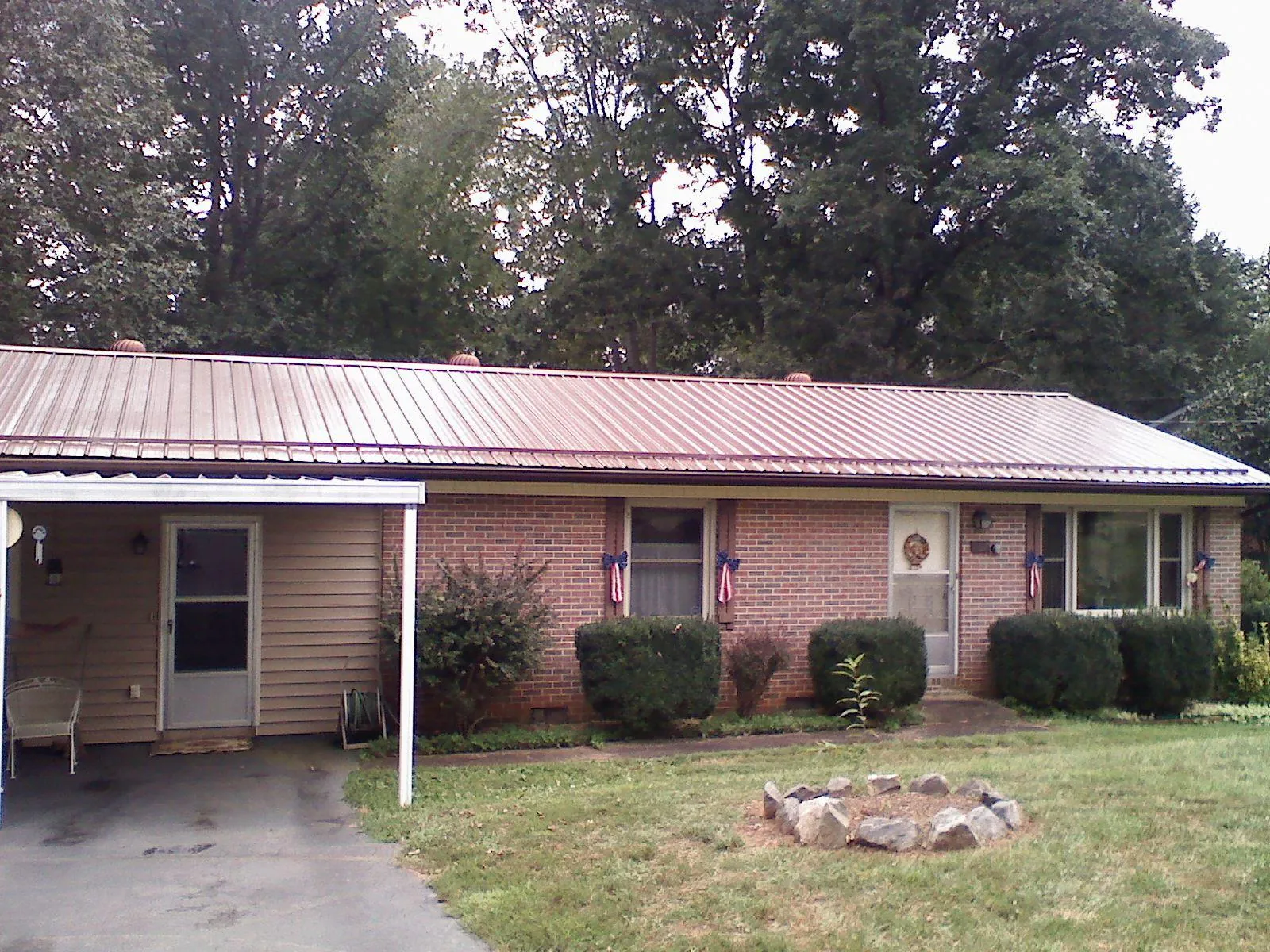Bronze metal roof and carport on a brick ranch home — Roof Repair work by our crew in Albany